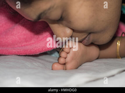 Madre baciare e consolante Baby Foto Stock