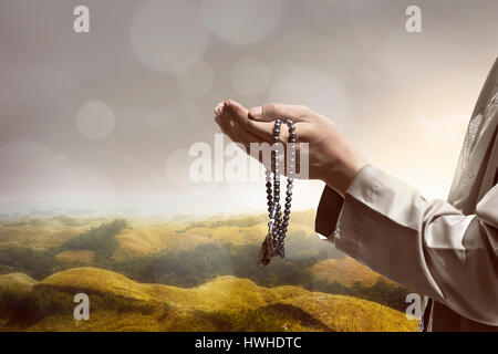 Canto del popolo musulmano di pregare con collina sullo sfondo del paesaggio Foto Stock