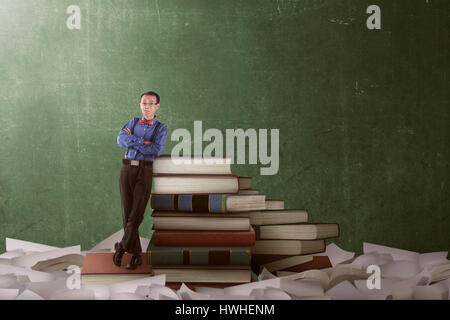Asian nerd uomo poggiando sui grandi libri. istruzione Concetto di immagine Foto Stock