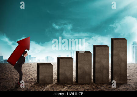 Asian business donna portare freccia andando ad aumentare il grafico Foto Stock