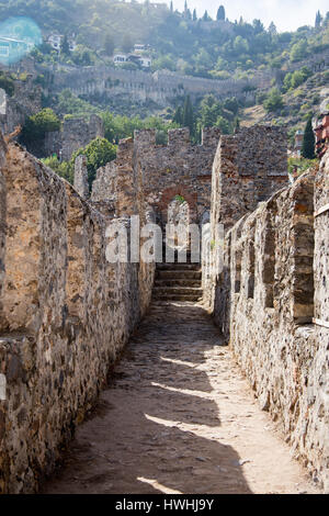 Delle mura del castello di Alanya con case di montagna e boschi di pini su sfondo Foto Stock