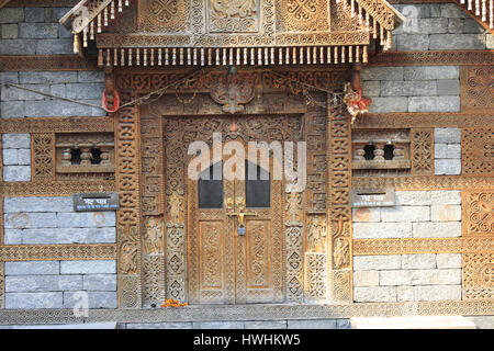 Close up di intricati intarsi in legno sulla porta di Jagati Patt tempio presso il castello di Naggar , Kulu Manali, Himachal Pradesh, India Foto Stock