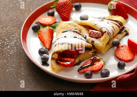 Frittelle sottili crepes con frutti di bosco per il dessert Foto Stock