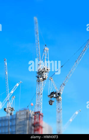 Miniaturizzati di Shot del sito di costruzione di gru lavorando su Edificio per uffici Foto Stock