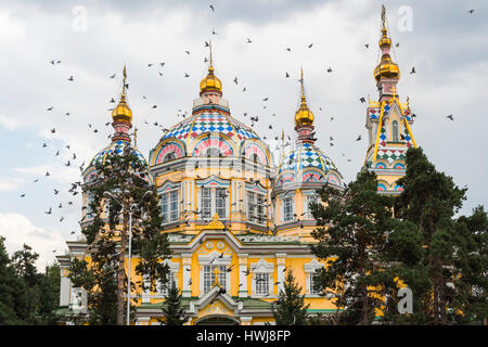 Piccioni volando sopra la cattedrale di ascensione o Cattedrale Zenkov, Panfilov Park, Almaty in Kazakistan e in Asia centrale Foto Stock