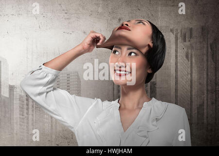 Asian business donna rimuovere altri suoi maschera facciale. Cambiare umore concept Foto Stock