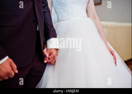 Mano nella mano di sposo e sposa cerimonia Chiesa. Foto Stock