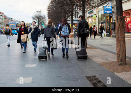 Tre turisti gente camminare lungo la trafficata strada oconnell sentiero Dublino Repubblica di Irlanda Foto Stock