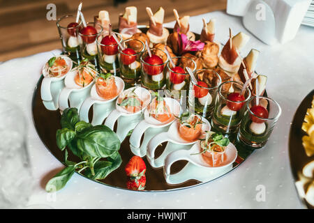 Delizioso sushi rotoli sulla piastra nera, decorate spuntini di frutta Foto Stock