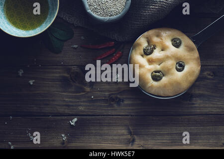 Italiano tradizionale focaccia alle olive verdi su legno backround. Foto Stock