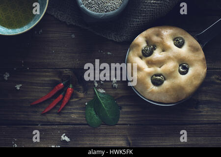 Italiano tradizionale focaccia alle olive verdi su legno backround. Foto Stock