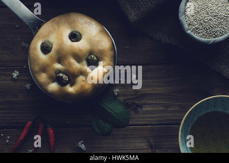 Italiano tradizionale focaccia alle olive verdi su legno backround. Foto Stock