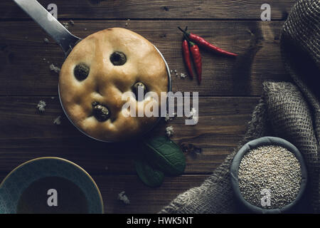 Italiano tradizionale focaccia alle olive verdi su legno backround. Foto Stock