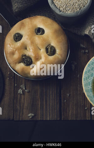 Italiano tradizionale focaccia alle olive verdi su legno backround. Foto Stock
