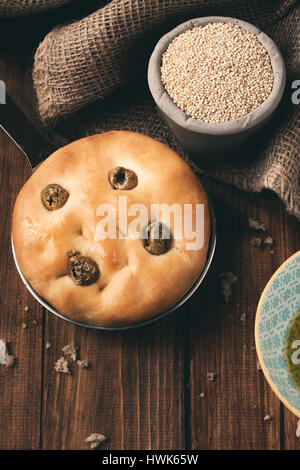 Italiano tradizionale focaccia alle olive verdi su legno backround. Foto Stock