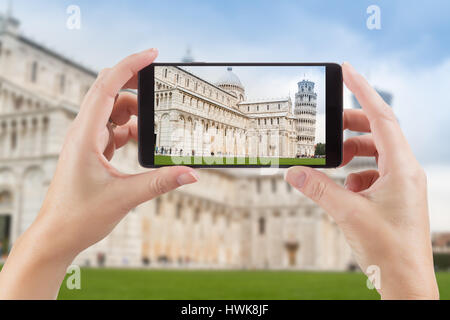 Mani femminili Azienda Smart Phone Visualizzazione delle foto di La Torre Pendente di Pisa dietro. Foto Stock