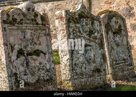 Chiusura del vecchio lichen coperto lapidi pendente, Morham sagrato, East Lothian, Scozia, la più piccola parrocchia in Scozia Foto Stock