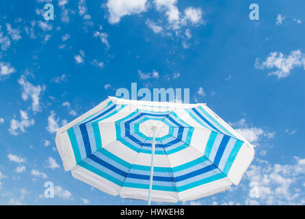 Striped ombrellone sotto il cielo blu, vacanze estive Foto Stock