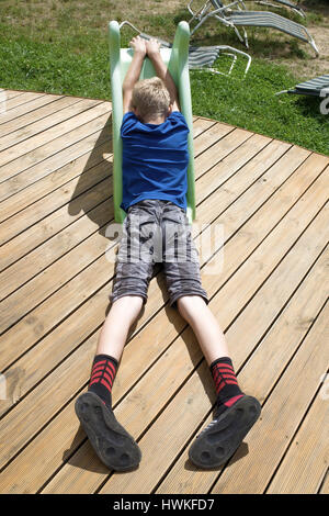 Ragazzo nel profondo pensiero posa su un kiddy scorrere sul suo deck. Il polacco bambino età 12 musando l. Zawady Polonia centrale Europa Foto Stock