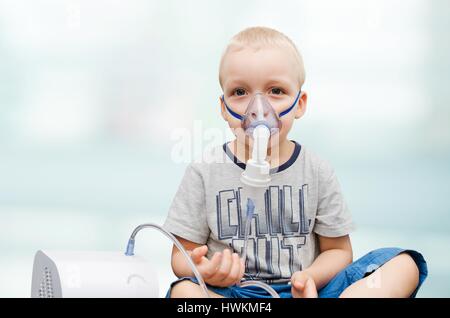 Bambino rendendo inalazione con maschera sul suo volto. Problemi di asma concept Foto Stock