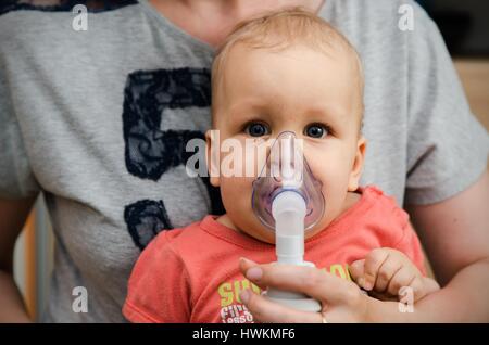 Bambino rendendo inalazione con maschera sul suo volto. Problemi di asma concept Foto Stock