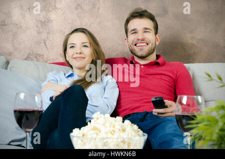 Giovane gode di tempo libero e guardare la tv. giovane guardando film casa divertente guardare la tv camera concept Foto Stock