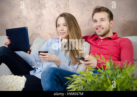 Giovane gode di tempo libero e guardare la tv. giovane guardando film casa divertente guardare la tv camera concept Foto Stock