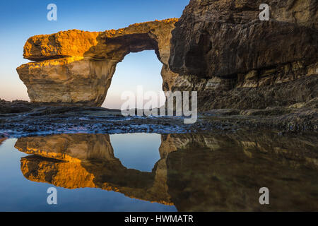 A Gozo, Malta - Sunriseat bellissima Azure Window, un arco naturale e il famoso punto di riferimento sull'isola di Gozo con la riflessione. È stato collassato su 9 Foto Stock