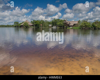 Sky, alberi e case si riflette nel fiume nel tardo pomeriggio, Santo Tomas, Perù Foto Stock