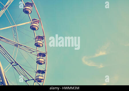 Vintage immagine stilizzata di una ruota panoramica Ferris contro il cielo blu, copia dello spazio. Foto Stock