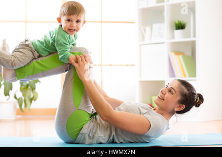 Madre di famiglia e kid figlio sono impegnati nella meditazione e yoga, esercitare a casa Foto Stock