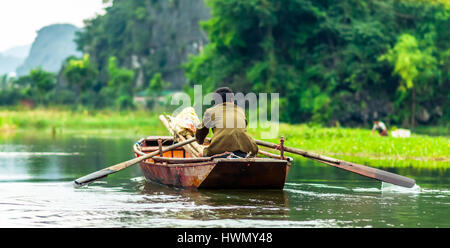 Vista sull'uomo in barca a remi da Nin Binh in Vietnam Foto Stock