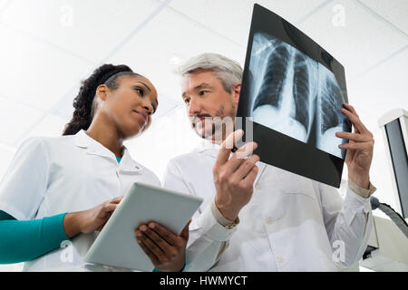 I radiologi con raggi X utilizzando Computer tablet in ospedale Foto Stock