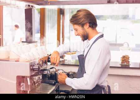 Immagine grafica di flare contro bello barista bollitore per caffè Foto Stock