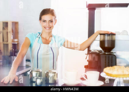 Immagine grafica di flare contro certi sorridente barista preparazione presso la caffetteria Foto Stock