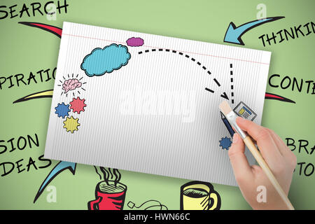 Mano che tiene il pennello contro lo sfondo di colore verde Foto Stock