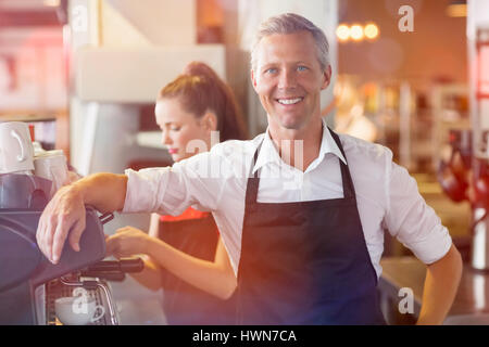 Immagine grafica di flare contro barista sorridente verso la telecamera Foto Stock