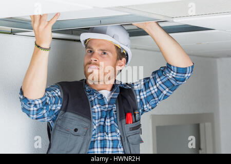 Elettriche Cablaggio lavoratore nel soffitto Foto Stock