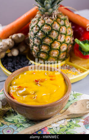 Ciotola di verdura salsa al curry e gli ingredienti che entrano nella rendendo - paprica, peperoncino, carote, ananas, gember. Ampiamente utilizzato in cucina indiana. Foto Stock