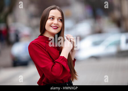 Brunette capelli donna spazzolare i capelli con una spazzola e sorridente Foto Stock