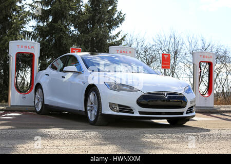 PAIMIO, Finlandia - 18 Marzo 2017: Bianco Tesla Model S P85D auto elettrica è in carica di Tesla sovralimentatore. Il sovralimentatore stazioni aggiungere ca Foto Stock