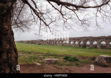 Le rovine di un antico acquedotto romano, realizzati in blocchi di tufo. Fotografato su un nuvoloso mattina di primavera. Foto Stock