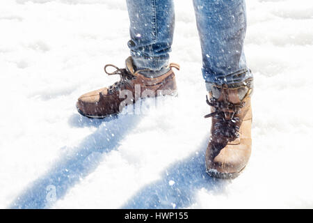Primo piano del mans gambe in piedi nella neve Foto Stock
