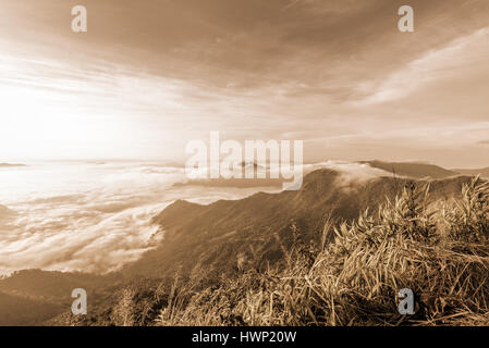 Vintage colore seppia stile, bellissima natura di paesaggio di alba sulle nuvole vista dalla montagna di picco con sun la nebbia e il cielo luminoso di Phu Chi fa Foto Stock