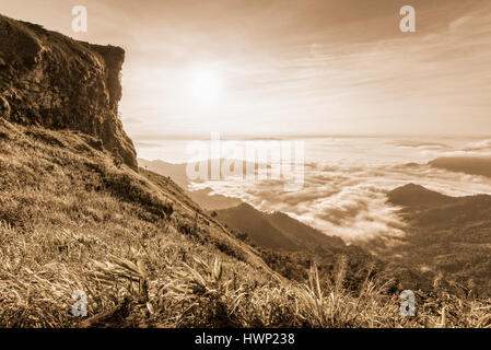 Vintage colore seppia stile, bellissima natura di paesaggio di alba sulle nuvole vista dalla montagna di picco con sun la nebbia e il cielo luminoso di Phu Chi fa Foto Stock