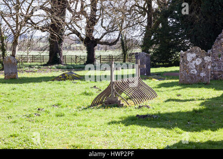 Una vecchia tomba incorniciata in metallo, la chiesa di San Leonardo, nel villaggio di Sutton Veny, Wiltshire, Inghilterra, Regno Unito Foto Stock