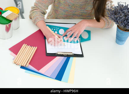 Persone creative workplace. Vista ravvicinata delle mani del giovane designer donna lavora con tavolozza di colori alla scrivania in ufficio. Modello allettante scelta di colore Foto Stock