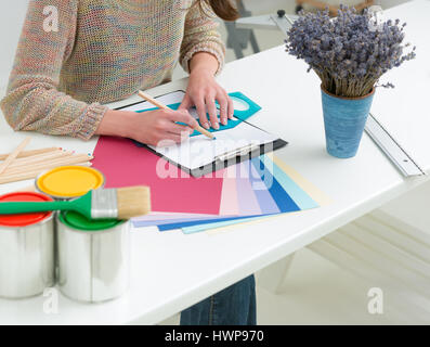 Persone creative workplace. Vista ravvicinata delle mani del giovane designer donna lavora con tavolozza di colori alla scrivania in ufficio. Modello allettante scelta di colore Foto Stock