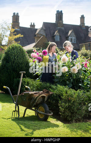 Re. La Terra giardinieri Henrietta Courtauld e Bridget Elworthy realizzare il compost a Wardington Manor vicino a Banbury, Oxfordshire - diffusione di compost tra Foto Stock