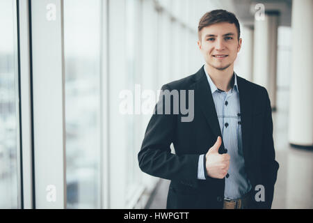 Giovane uomo d affari andando pollice in alto l'ufficio Foto Stock